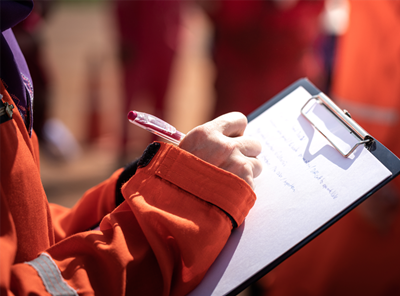 Image of person writing on a clipboard